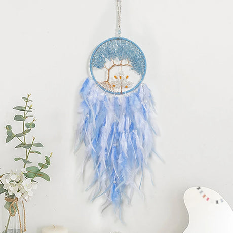 Blue and white dreamcatcher with feathers on a white background