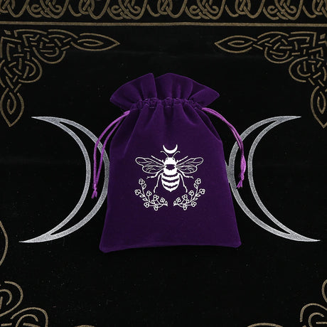 Purple drawstring bag with a white bee design on a black background with moon symbols.