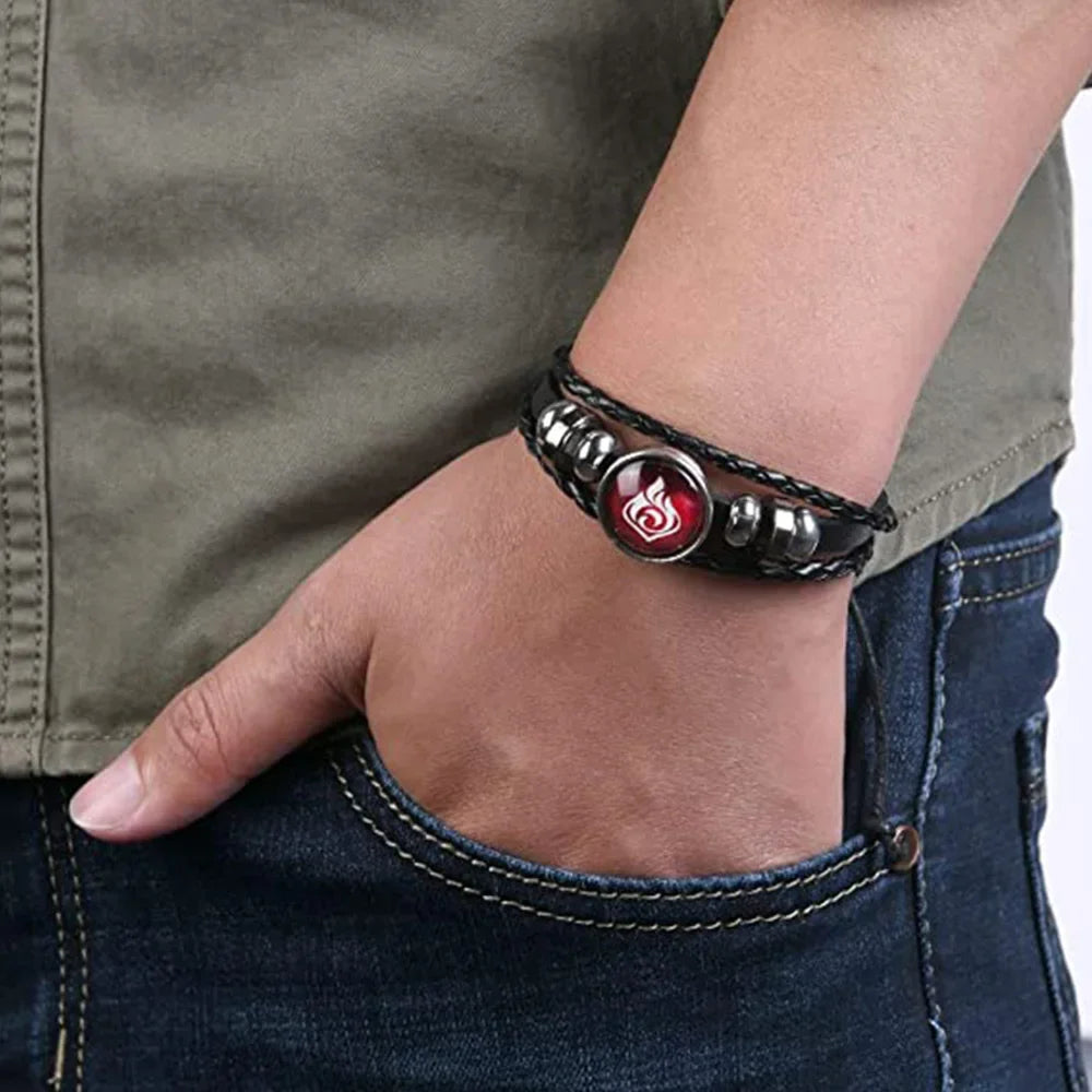 Bracelet with a red and silver charm on a wrist, wearing a green shirt and blue jeans.