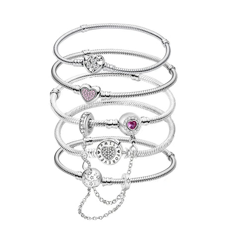 Stack of silver bracelets with heart-shaped charms on a white background