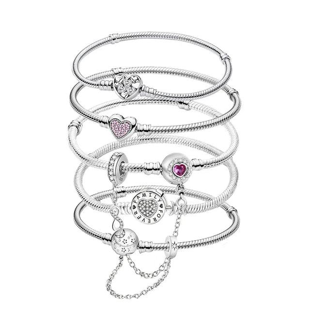 Stack of silver bracelets with heart-shaped charms on a white background
