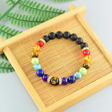 Colorful beaded bracelet on a wooden tray with green leaves in the background