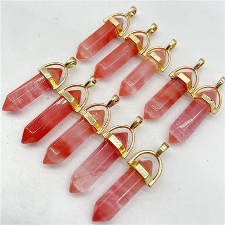 Pink crystal pendants with gold accents on a white background