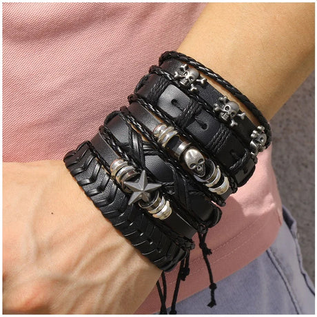 Black leather bracelets with metal beads on a wrist against a pink shirt background