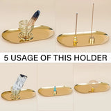 Gold incense holder with various incense sticks on a beige background