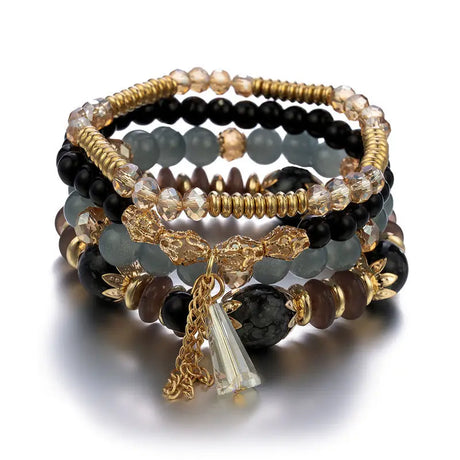 Stack of beaded bracelets with gold accents and a tassel charm on a white background