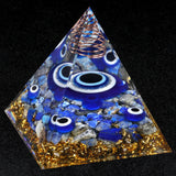 Pyramid-shaped object with blue eyes and gold accents on a black background