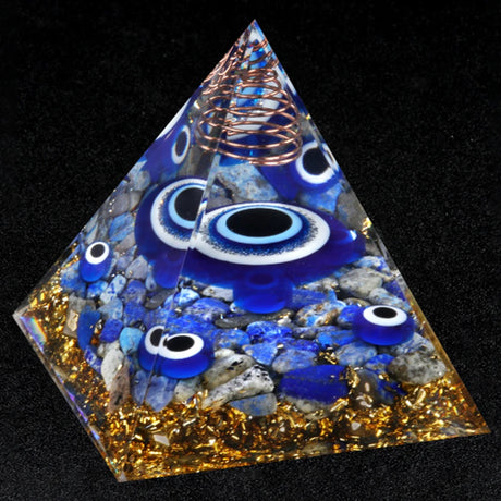 Pyramid-shaped object with blue eyes and gold accents on a black background
