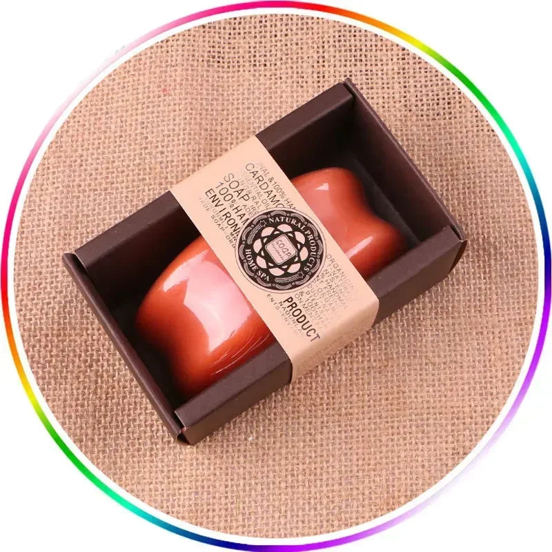 Two red soaps in a brown box with a natural label on a textured beige background.