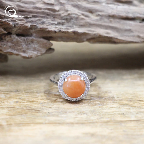Ring with a pink stone on a wooden surface