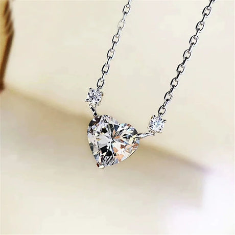 Heart-shaped diamond pendant on a chain with a soft background