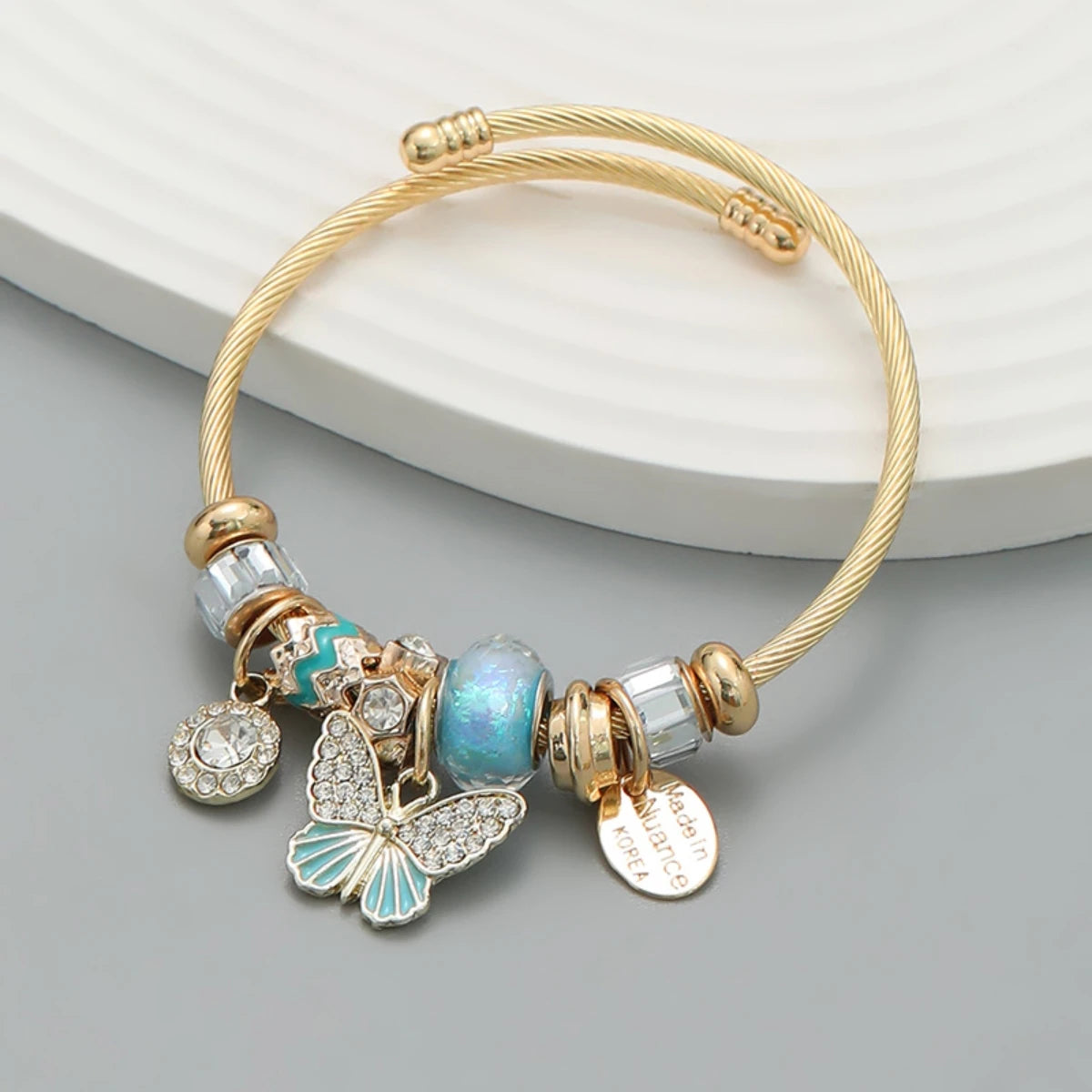 Gold bracelet with charms on a gray surface