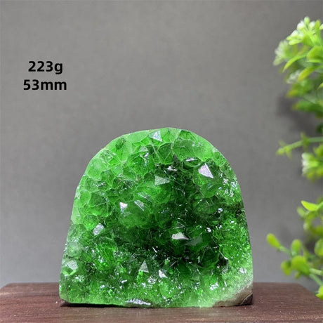 Green crystal rock on a wooden surface with a gray background
