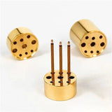 Gold cylindrical candle holders with wooden sticks on a white background