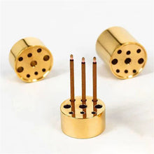 Gold cylindrical candle holders with wooden sticks on a white background