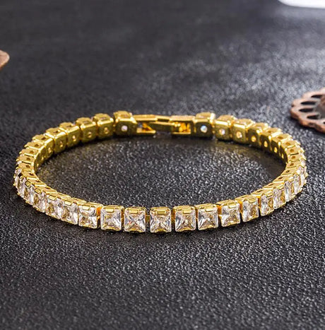 Gold bracelet with clear stones on a dark textured surface