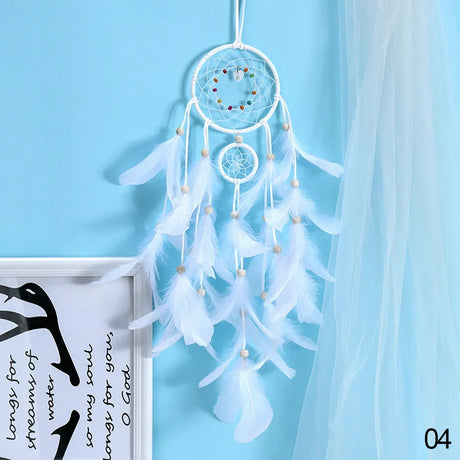 White dreamcatcher with feathers against a light blue background