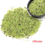 Olivine stones with a bowl of stones on a white background.