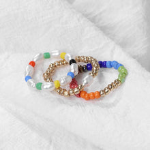 Set of colorful beaded bracelets on a white fabric background