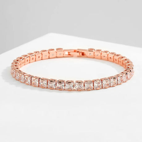 Rose gold bracelet with clear gemstones on a light gray background