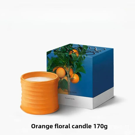 Orange floral candle with packaging on a white background