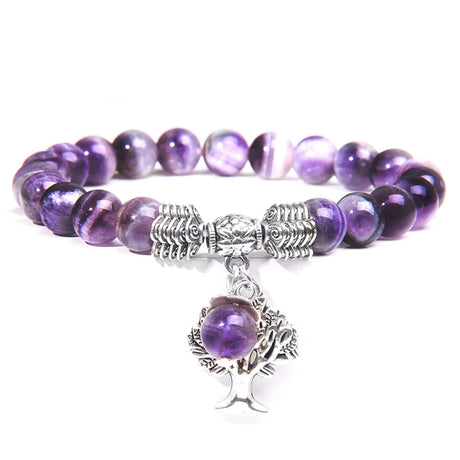 Purple beaded bracelet with a silver tree of life charm on a white background