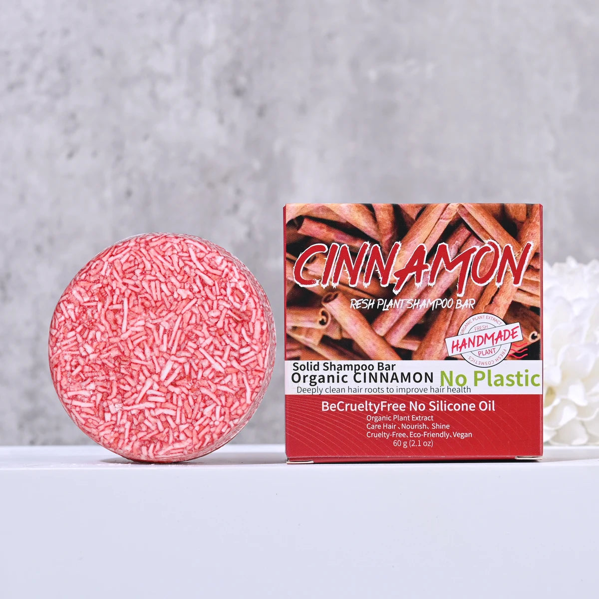 Cinnamon-scented solid shampoo bar with packaging on a gray background