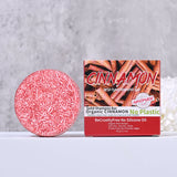 Cinnamon-scented solid shampoo bar with packaging on a gray background