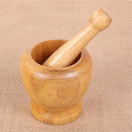 Wooden mortar and pestle on a beige fabric background