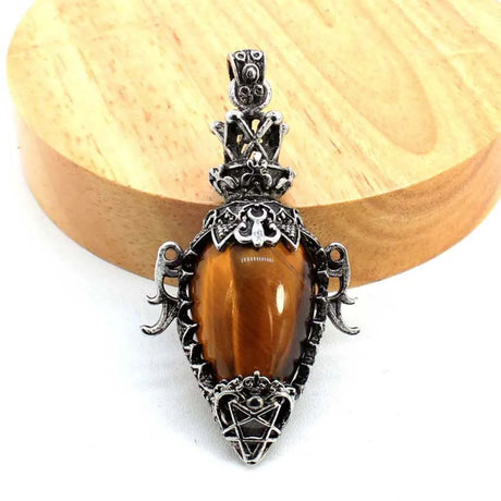 Decorative pendant with a brown gemstone on a wooden surface