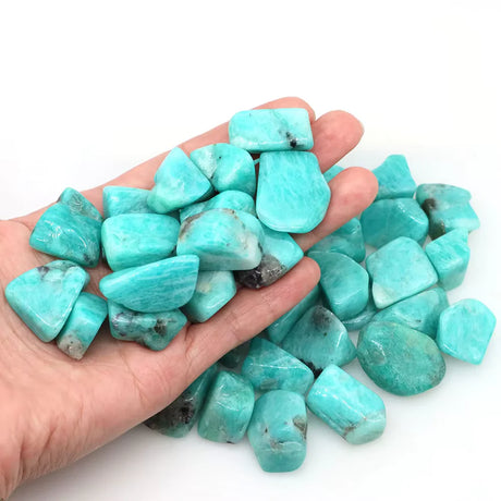 Turquoise stones held in a hand on a white background