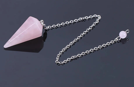 Pink crystal pendant on a chain with a dark background
