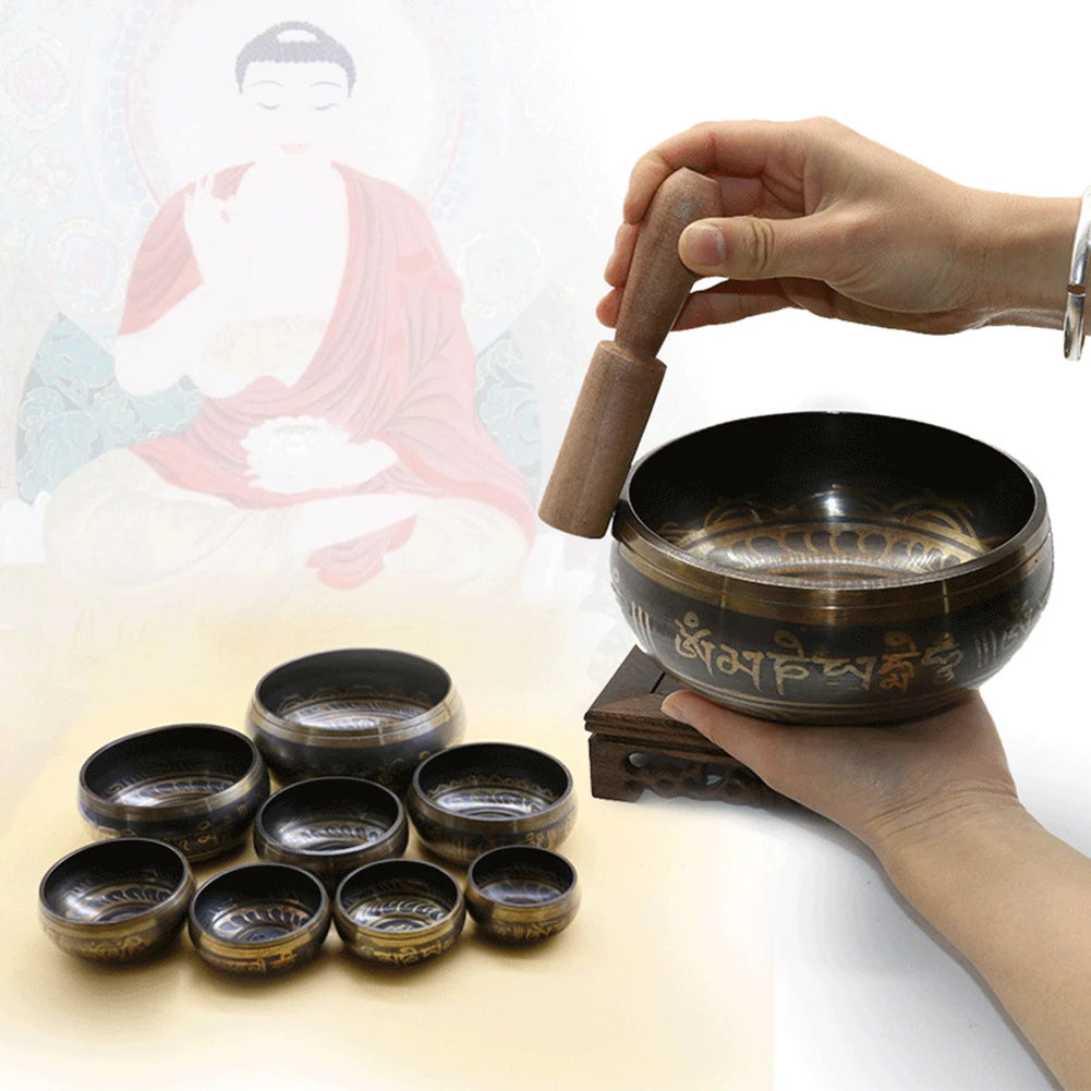 Person striking a tibetan singing bowl with other bowls on a white background