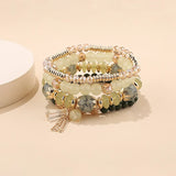 Stack of beaded bracelets with gold accents on a beige background