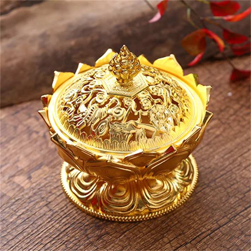 Gold decorative item with intricate designs on a wooden surface