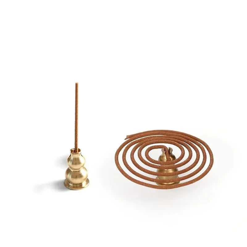 Brass incense holder with a coil of incense on a white background