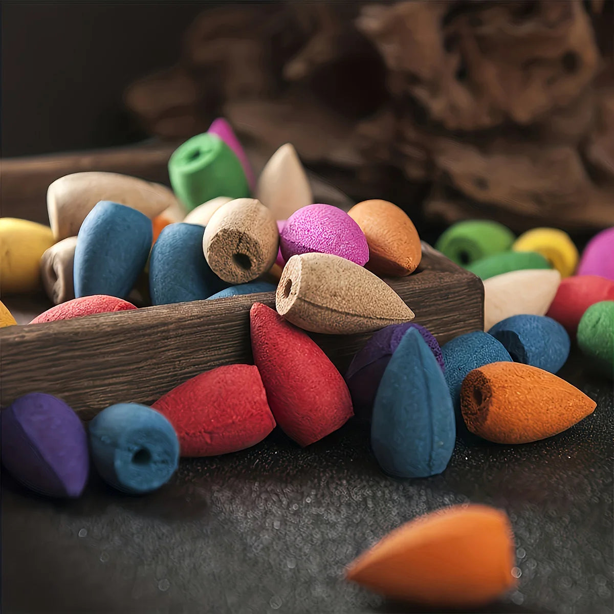 Colorful wooden beads in a wooden box on a dark surface
