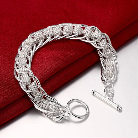 Silver braided bracelet on a red fabric background