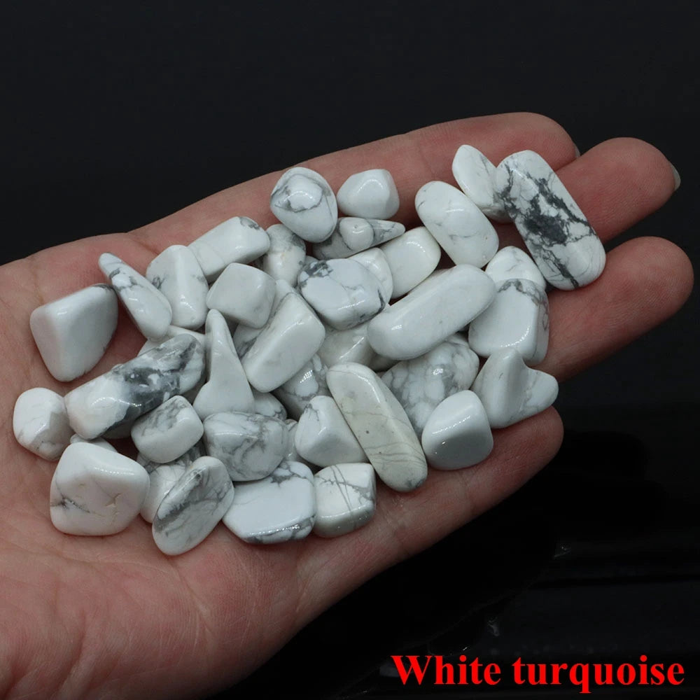 Hand holding white turquoise stones with a dark background