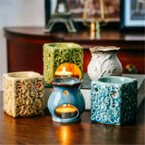 Set of decorative ceramic oil burners on a wooden surface