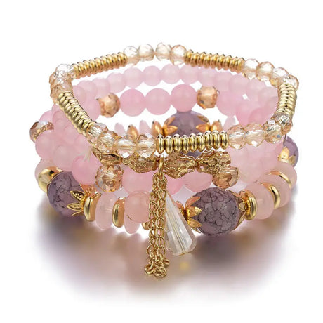 Stack of pink and gold beaded bracelets on a white background