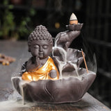 Buddha-shaped incense burner with incense sticks and smoke in a blurred background