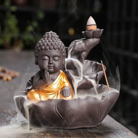 Buddha-shaped incense burner with incense sticks and smoke in a blurred background