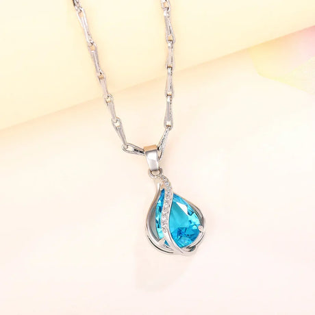 Necklace with a blue teardrop pendant on a light background