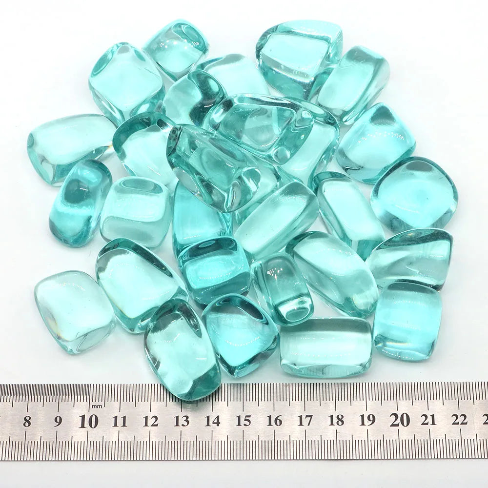 Turquoise glass beads with a ruler for scale on a white background