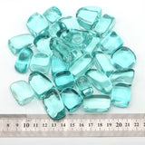 Turquoise glass beads with a ruler for scale on a white background