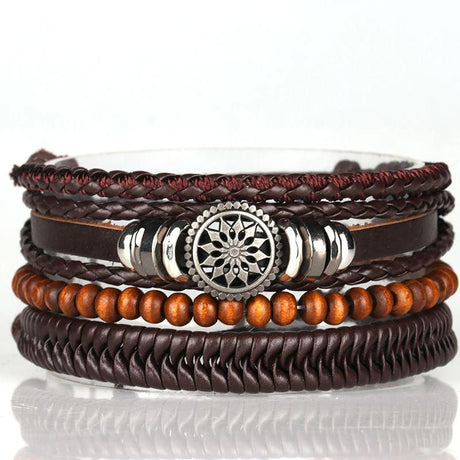 Stack of leather and beaded bracelets with a central silver emblem on a white background