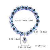 Bracelet with blue and black beads and a silver hamsa charm, showing measurements on a white background.