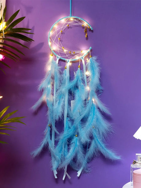 Turquoise dreamcatcher with feathers and string lights on a purple wall.