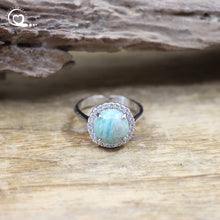 Ring with a turquoise stone and silver accents on a wooden surface